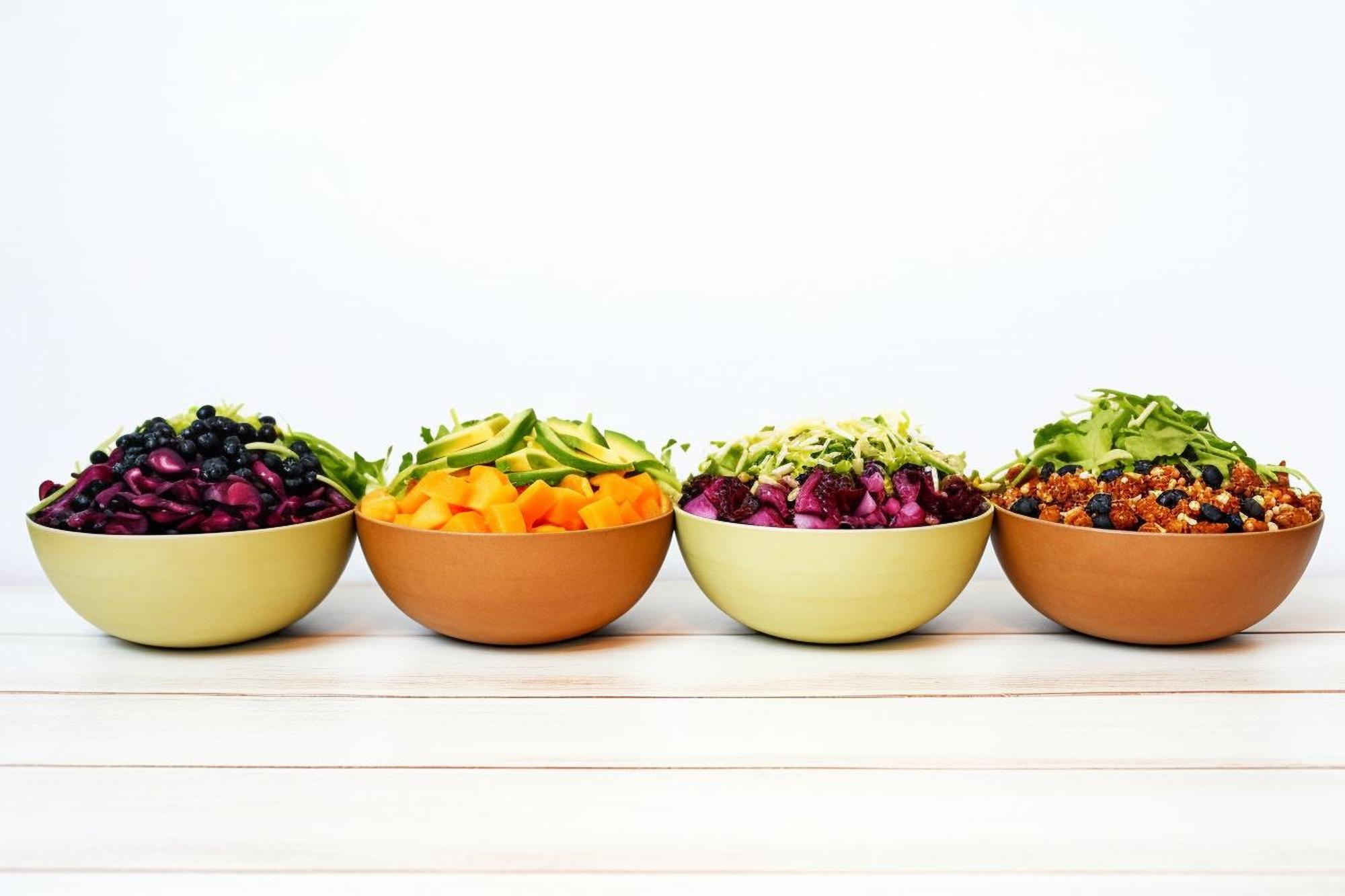 Stacked bowls with colorful salad and grain mix